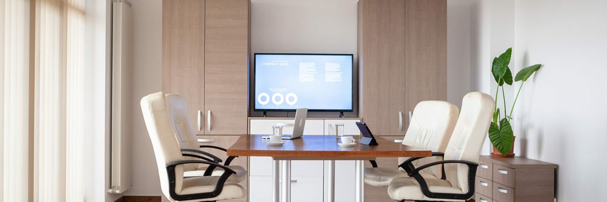 Empty conference room in business center with a TV in background Empty conference room in business center. There is a TV displaying some graphs and charts on the background